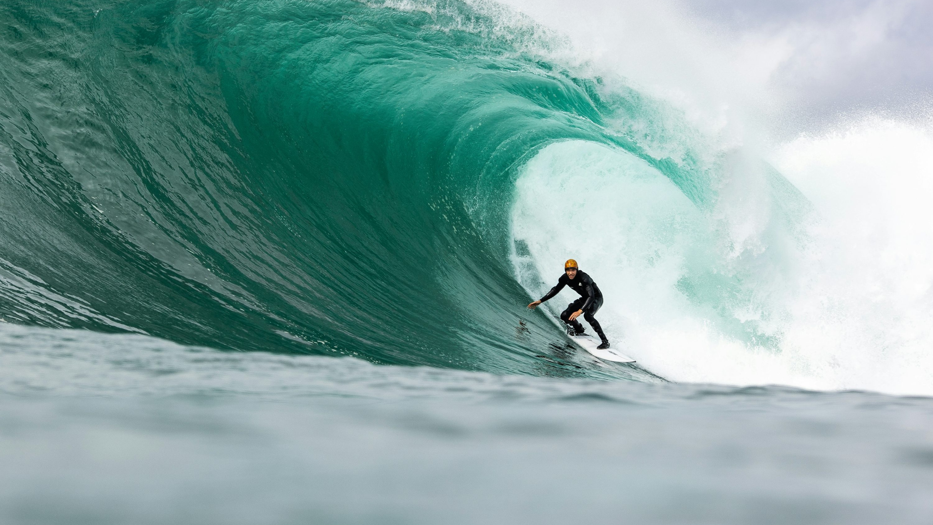 Surfer riding inside a barrel wave with turquoise water